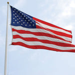 American flag flying on a pole against a blue sky, emphasizing its large 20x38 ft size and detailed appliqued stars and sewn stripes.