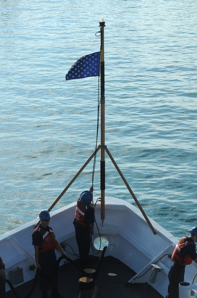 Group of people on a boat displaying the US Navy Union Jack Nylon Embroidered Stars 25 x 31 flag.