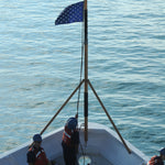 US Navy Union Jack Nylon Embroidered Stars 20 x 26 on a boat with people wearing life jackets, flag prominently displayed.