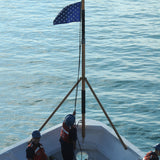 US Navy Union Jack Nylon Embroidered Stars 20 x 26 on a boat with people wearing life jackets, flag prominently displayed.