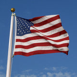 5' x 8' American Flag - Polyester US Flag with Embroidered Stars and Sewn Stripes, flying in the wind, highlighting durable construction and detailed craftsmanship.