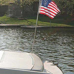 US Yacht Ensign Nylon Embroidered and Sewn Flag 16 x 24 flying on a boat, showing its detailed embroidered stars and sewn strips.