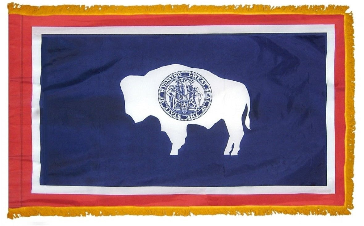 Wyoming State Flag 4' x 6' INDOOR Printed Nylon, featuring a buffalo symbol on a blue and white seal, with a flannel-lined pole sleeve and rayon fringe.